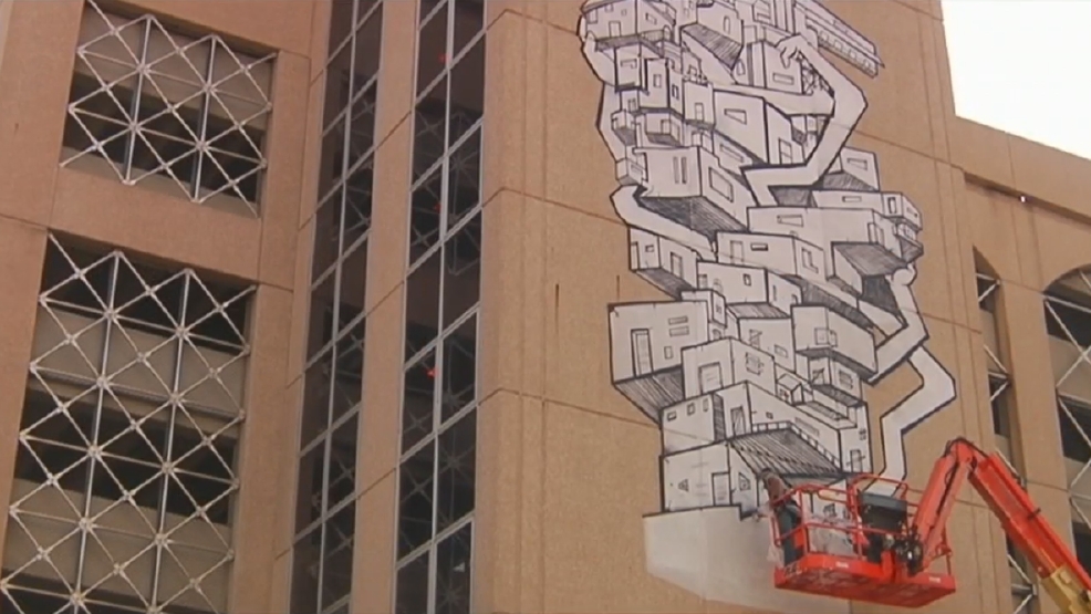 Artist painting mural in downtown Cedar Rapids KGAN